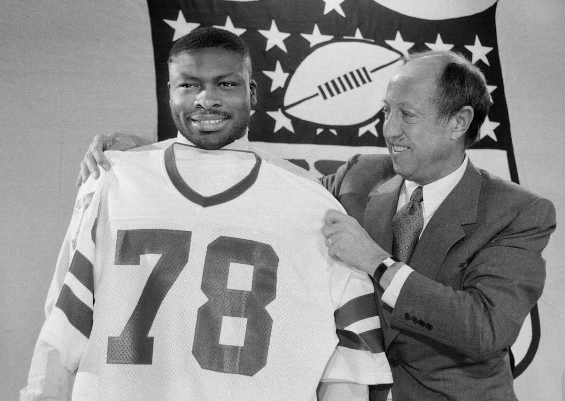 ** FILE ** Bruce Smith of Virginia Tech gets fitted for his new jersey by NFL commissioner Pete ...