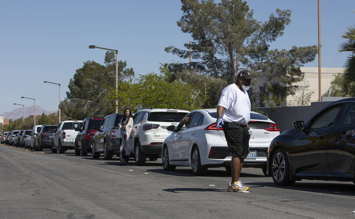 Drivers communicate with each other about the wait for drive-through COVID-19 antibody testing ...