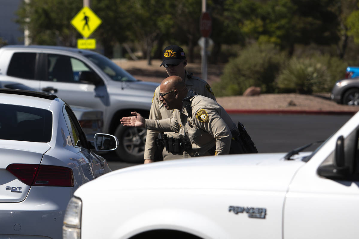 Police officers begin to inform those waiting in line for drive-through COVID-19 antibody testi ...