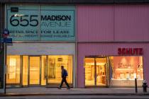 In a Thursday, March 19, 2020, photo, a pedestrian walks past a storefront for rent on Madison ...