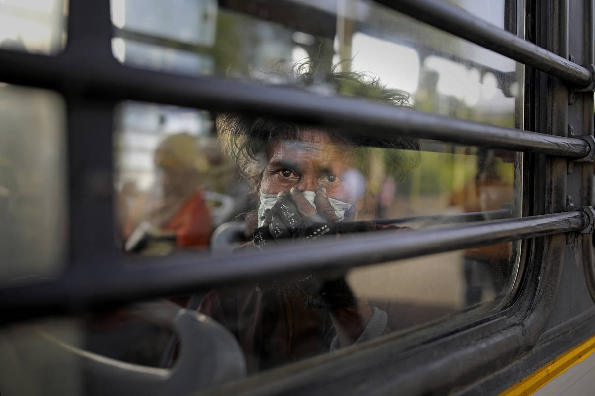 An Indian homeless man sits in a bus as he is being evicted with other homeless people and migr ...