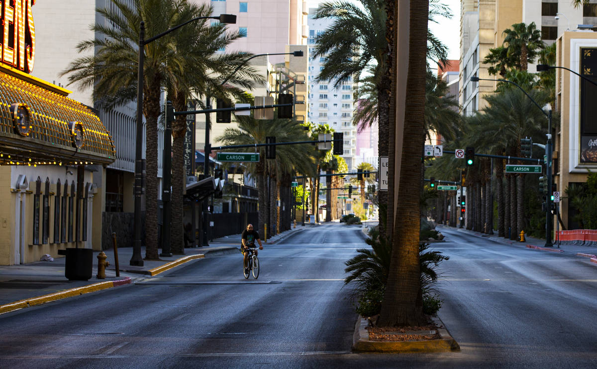 A man rides a bike down Casino Center Boulevard near Fremont Street as traffic remains light in ...