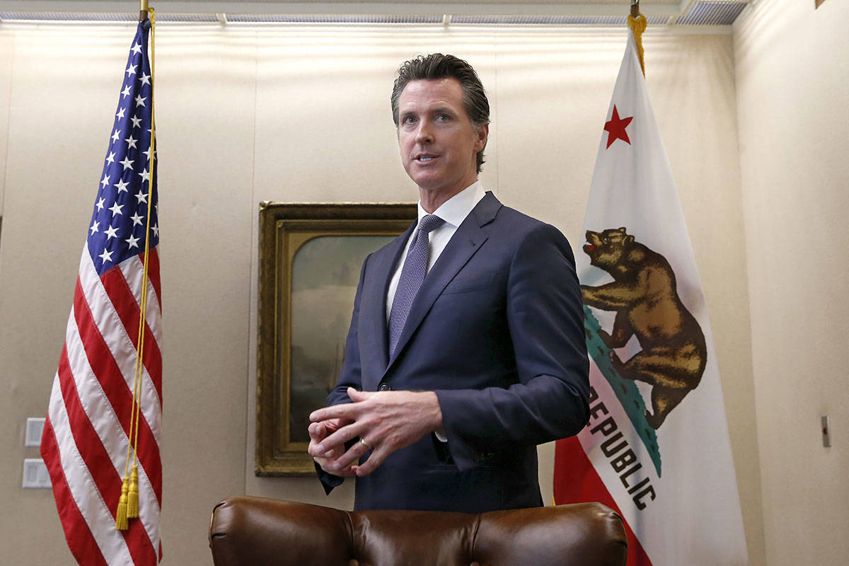 Gov. Gavin Newsom talks with reporters at his office in Sacramento, Calif., in 2019. (AP Photo/ ...
