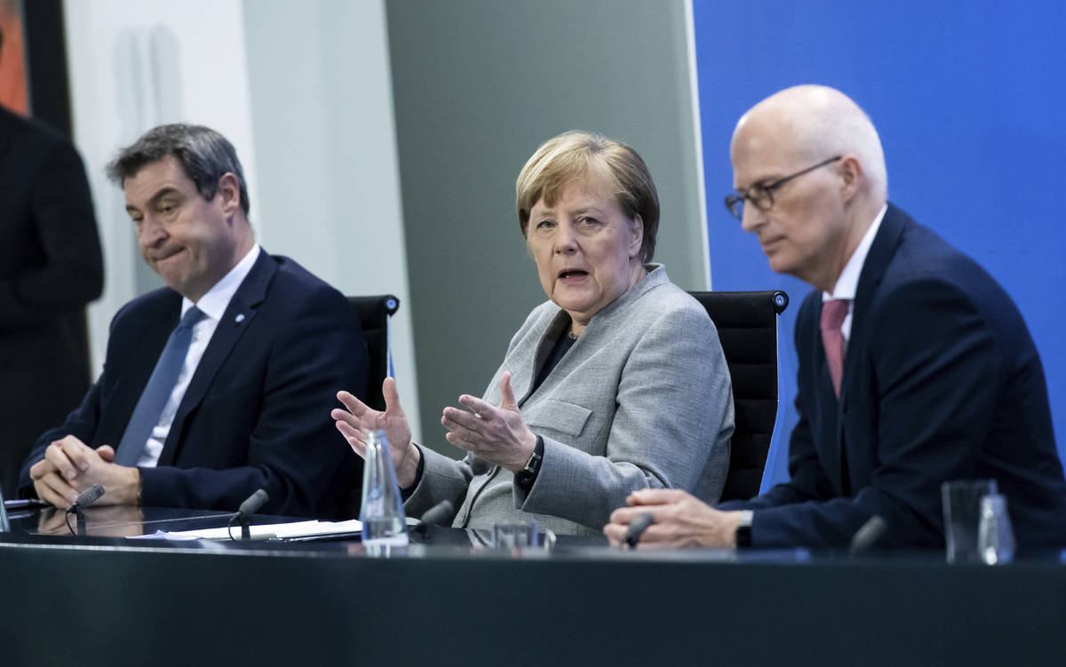 Markus Soder, Prime Minister of Bavaria, left, Germany's Chancellor Angela Merkel, center, and ...