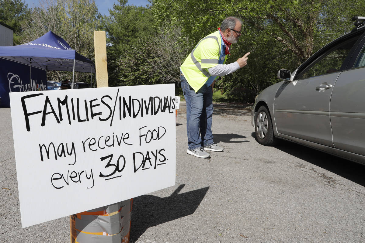 In this April 9, 2020, photo, Greg Perry talks to a driver arriving at GraceWorks Ministries fo ...