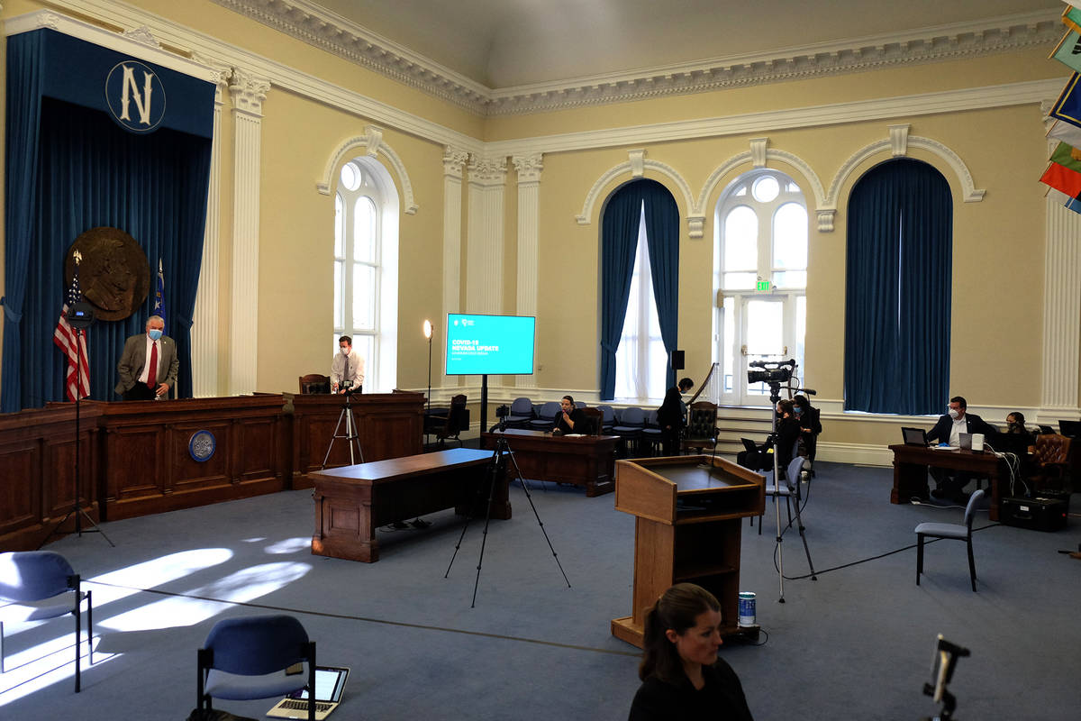 Reporters and members of the Gov. Steve Sisolak's staff observe physical distancing at the gove ...