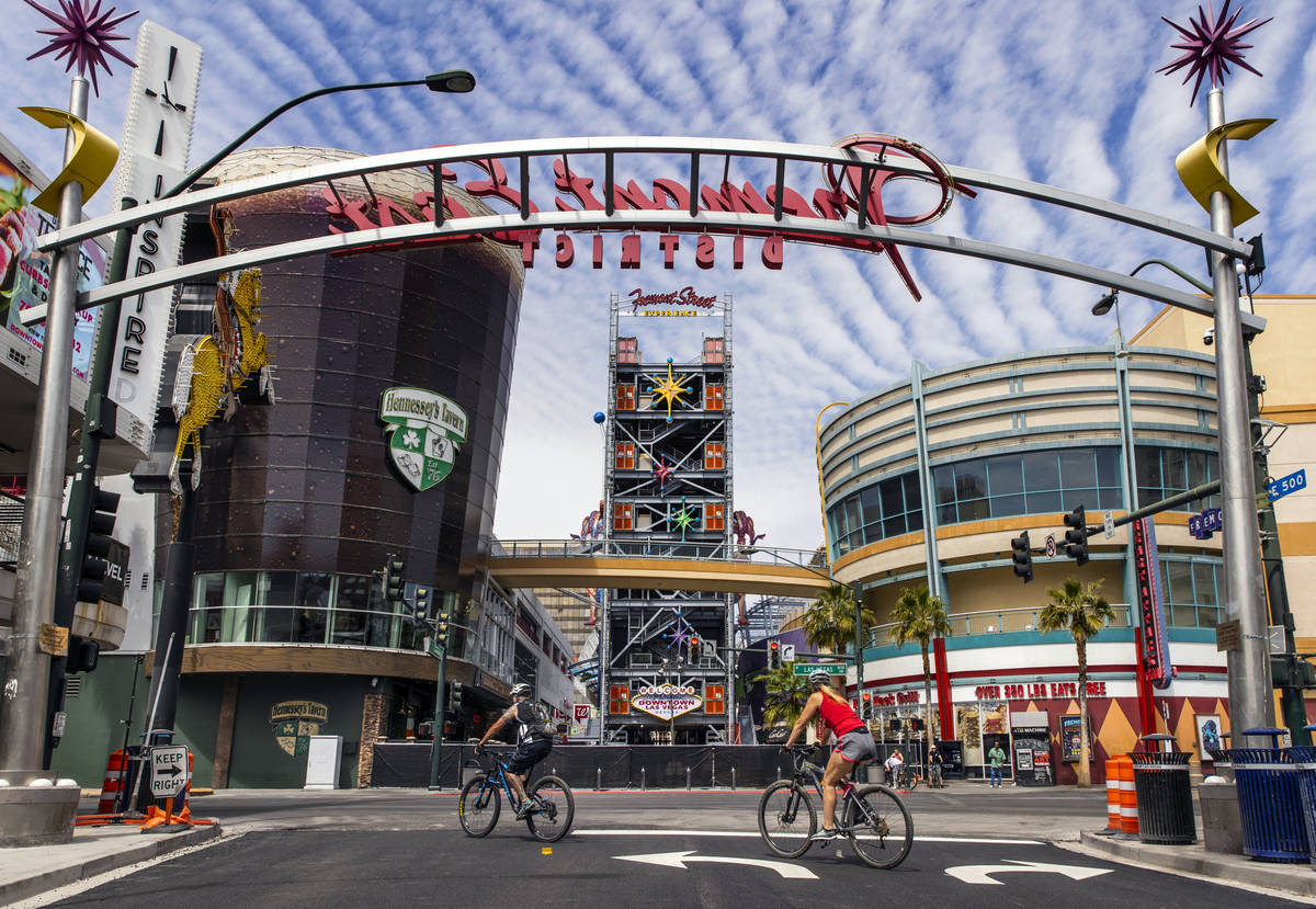 Cyclists ride past along an empty Fremont Street in Downtown Las Vegas during the novel coronav ...