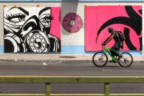 A cyclist rides past a mural by Franky Aguilar outside Donut Bar in Downtown Las Vegas on Su ...