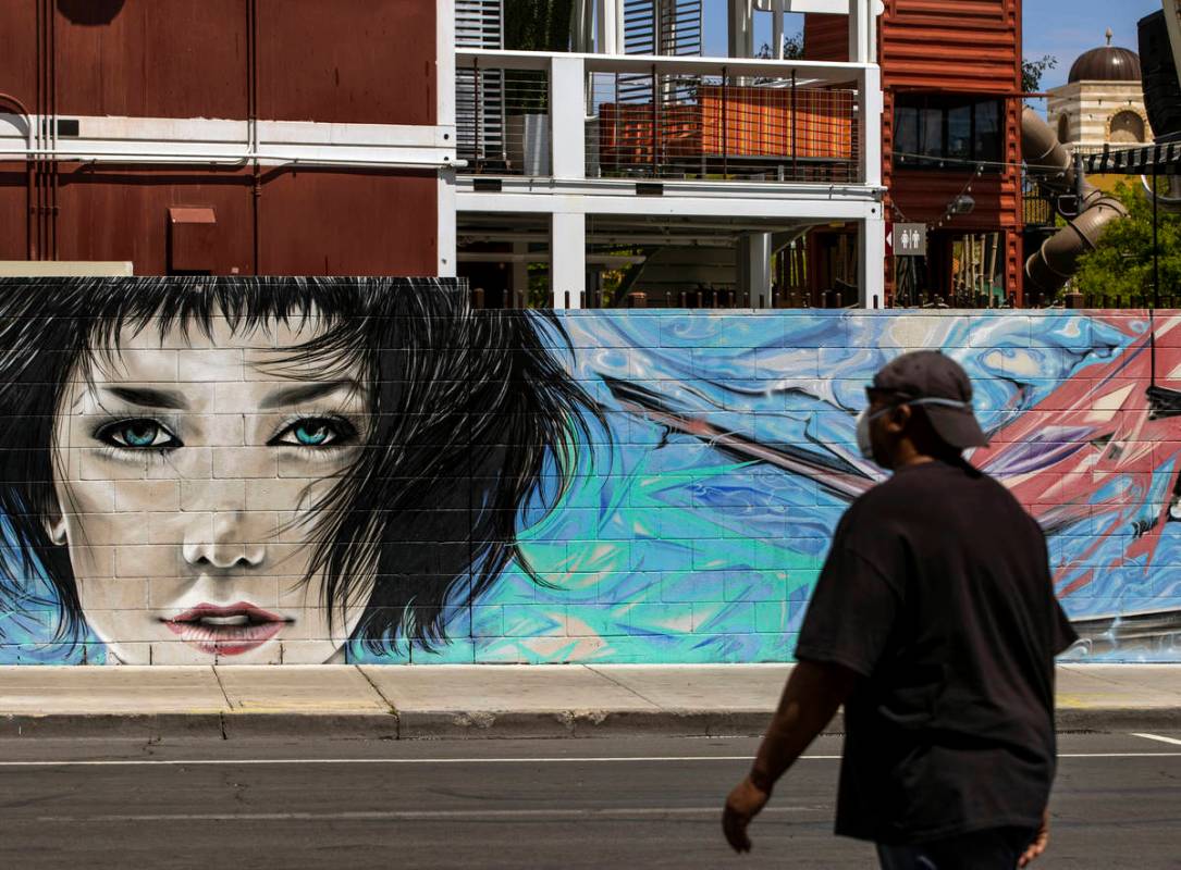 A pedestrian walks about a mural on the backside of Container Park along E. Carson Avenue in Do ...