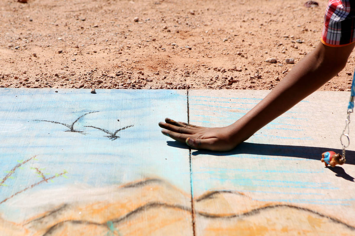 Tayen Cole-Burnside, 10, works on his chalk art in part of Chalk and Cheers at Skye Canyon Park ...