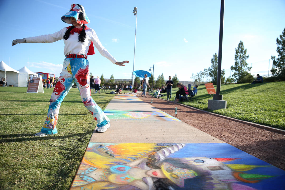 Artist Yun Ying Li walks around her chalk painting during the Chalktober Fest at Skye Canyon Pa ...