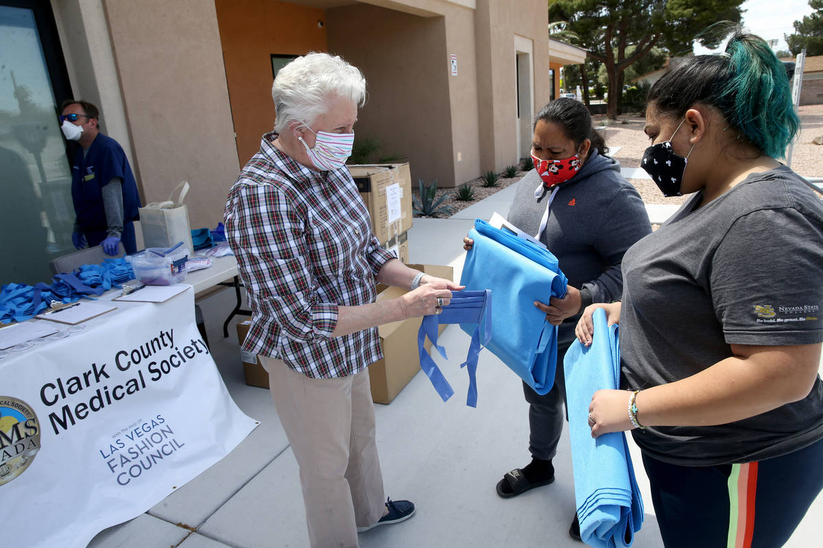 Denise Selleck, executive director of Clark County Medical Society, gives mask fabric to Rita O ...