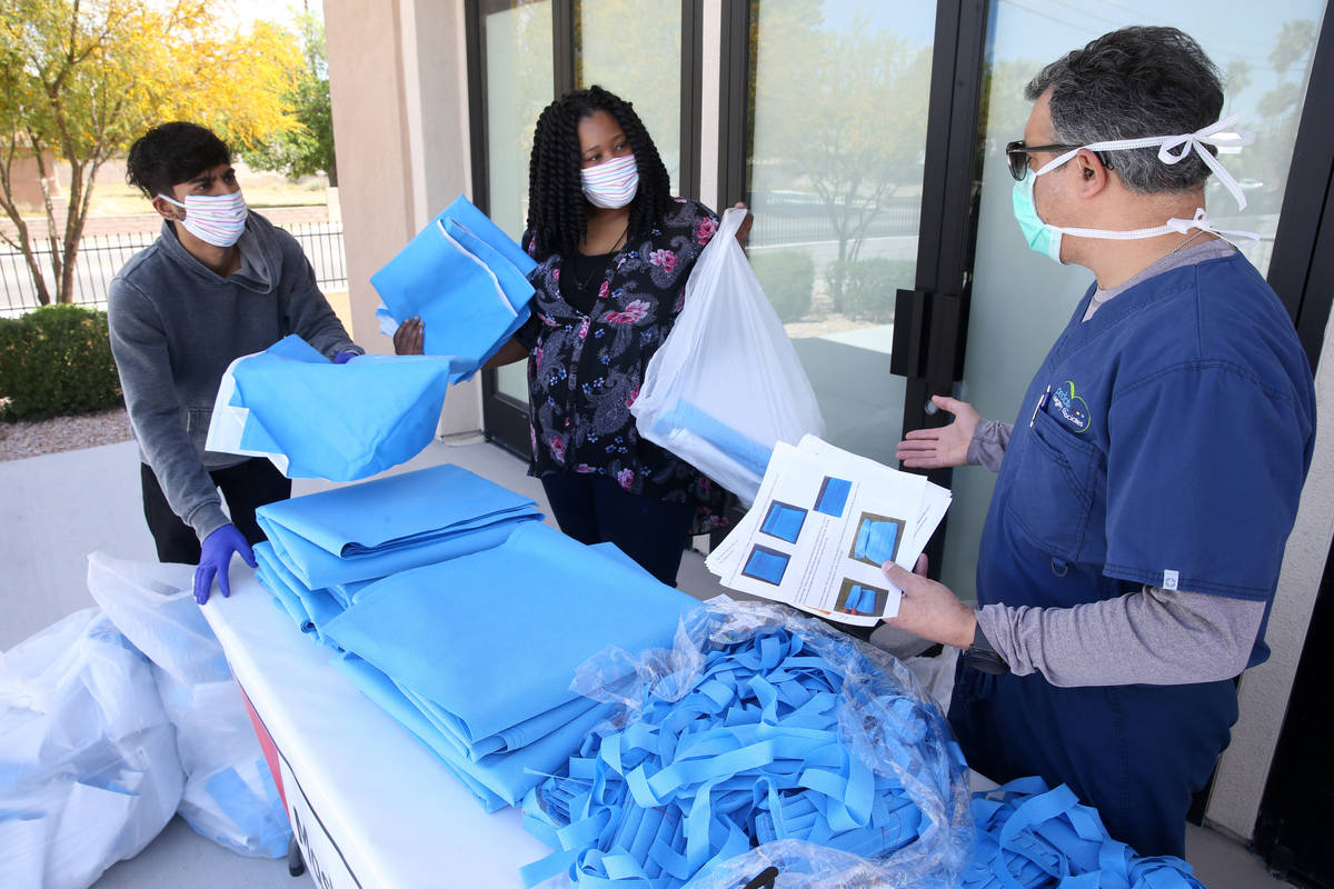Dr. Nicholas Fiore, right, organizes mask fabric with Brittany Green, and Shalan Hassim, of Cla ...