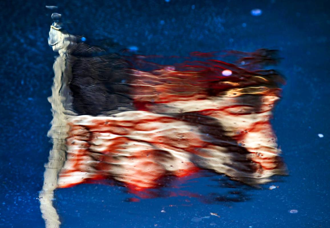 An American flag is reflected in a pool at New-York New-York along Las Vegas Boulevard on the S ...