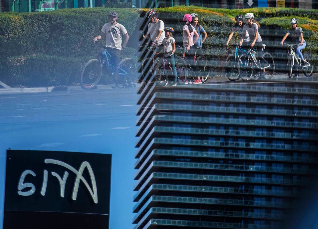 A large group of bicyclists wait at a light across from Aria on the Strip on Thursday, April 1 ...