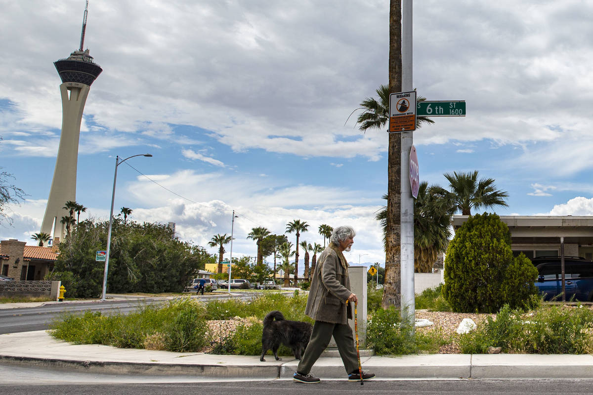 A man walks his dog in the historic Beverly Green neighborhood in Las Vegas on Saturday, April ...