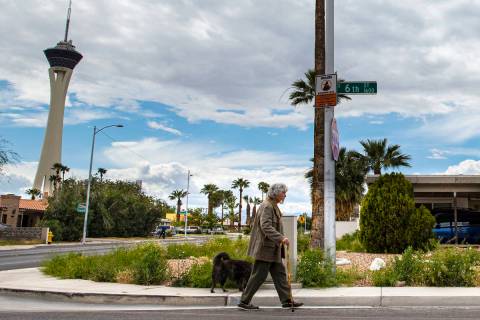 A man walks his dog in the historic Beverly Green neighborhood in Las Vegas on Saturday, April ...