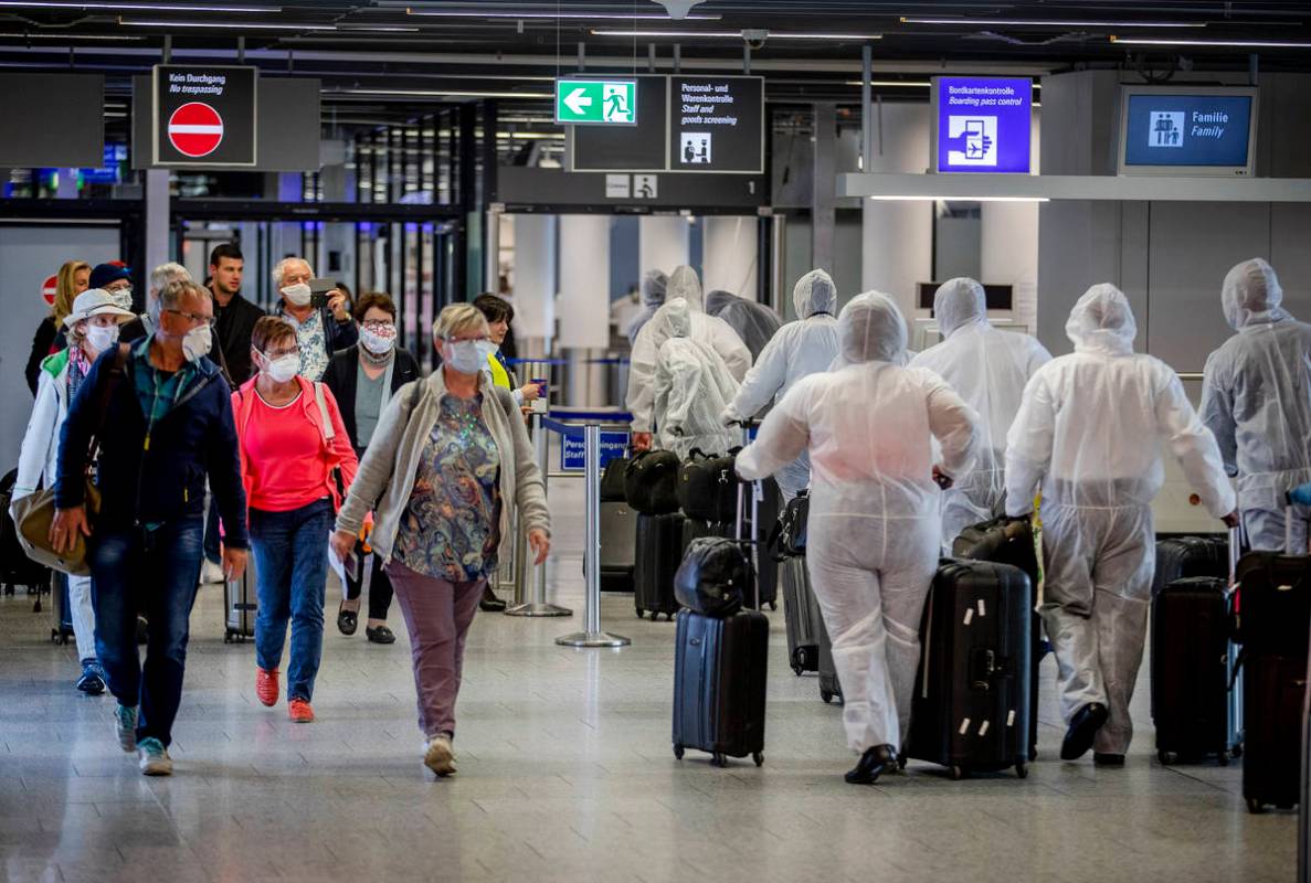 Passengers, left, who just arrived at the airport walk past crew members of South African Airwa ...