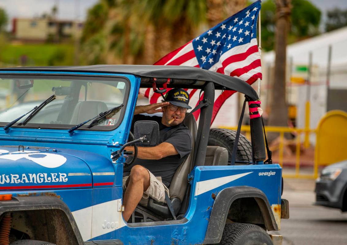 Greg Whalen salutes flag wavers as he follows others in for a protest at the Grant Sawyer State ...