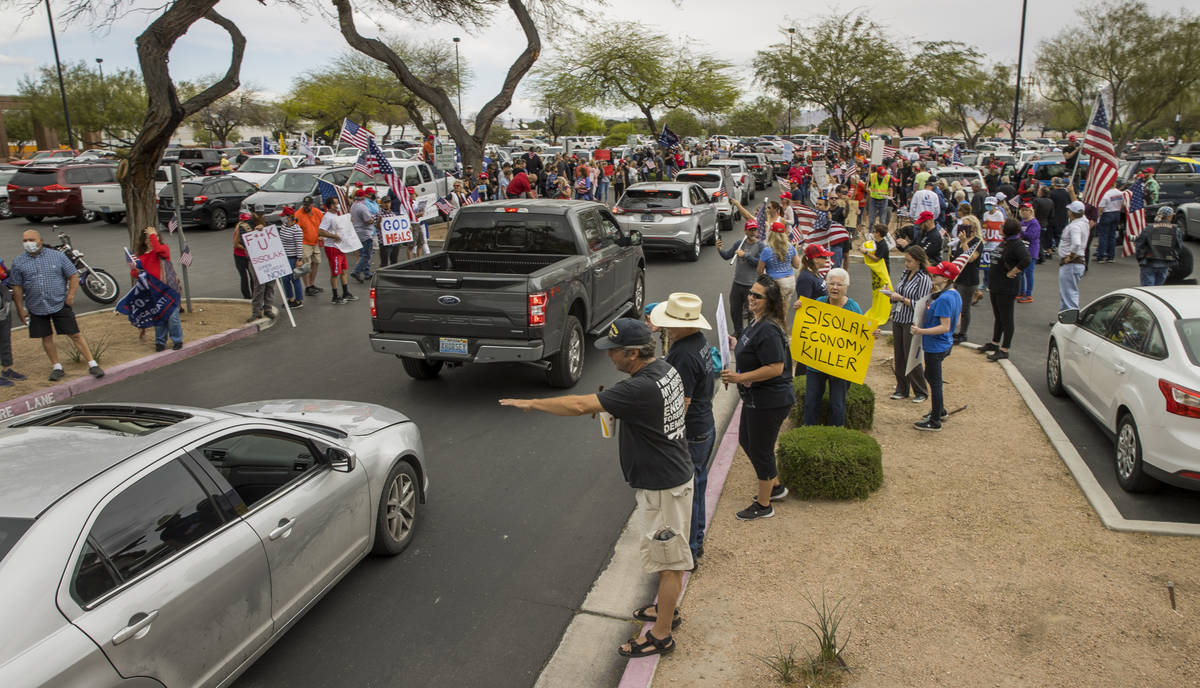 Protesters continue to welcome others arriving to the Reopen Nevada protest at the Grant Sawyer ...