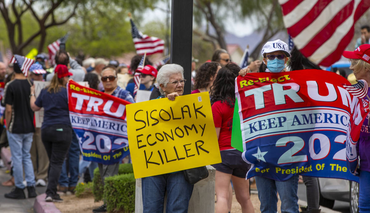 Carmen Rhoda, center, carries bright sign while joining the many others during the Reopen Nevad ...