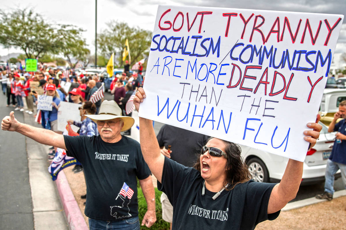 April Crooks, right, protests outside the Grant Sawyer State Office Building during an event or ...