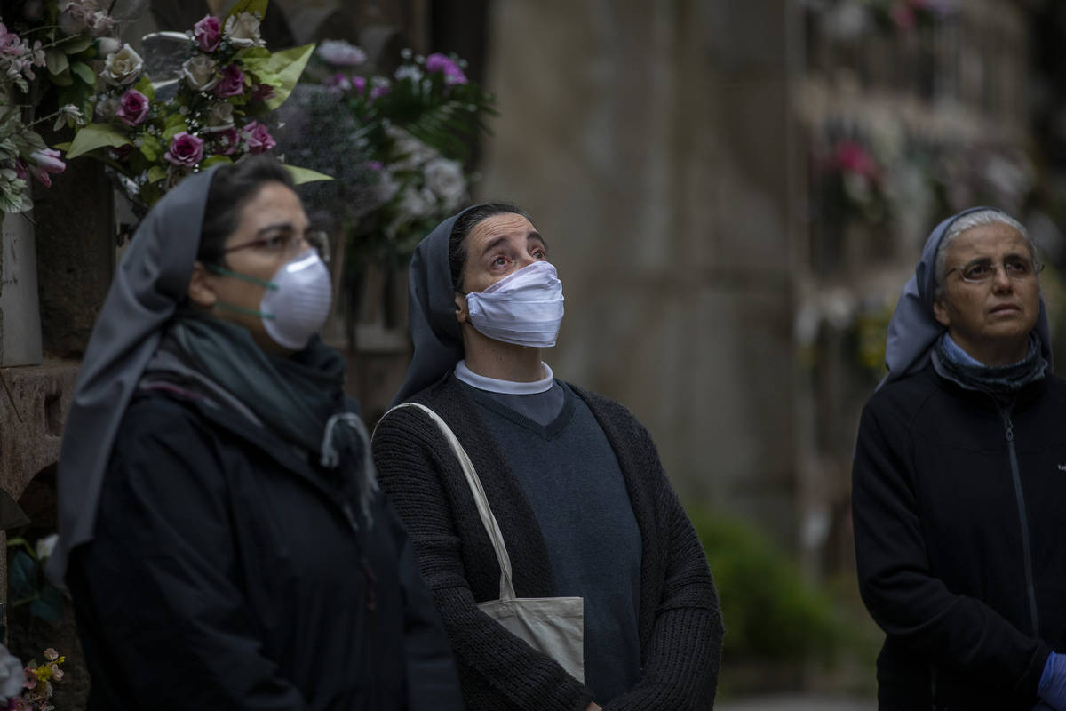 Three nuns look at the coffin of Inmaculada Louzan, a sister of Nazareth who died at age 80 of ...