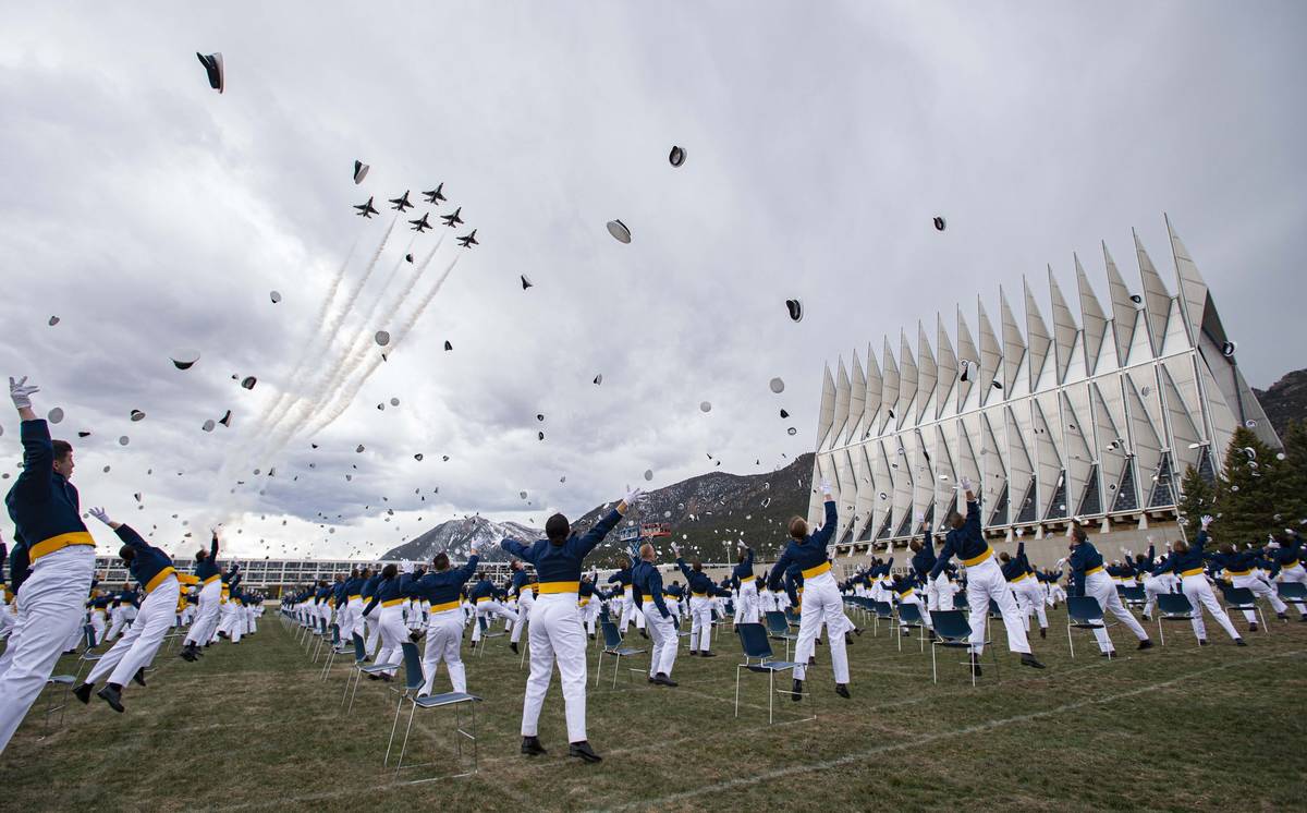 The class of 2020 toss their caps into the air as the Thunderbirds fly over Saturday, April 18, ...