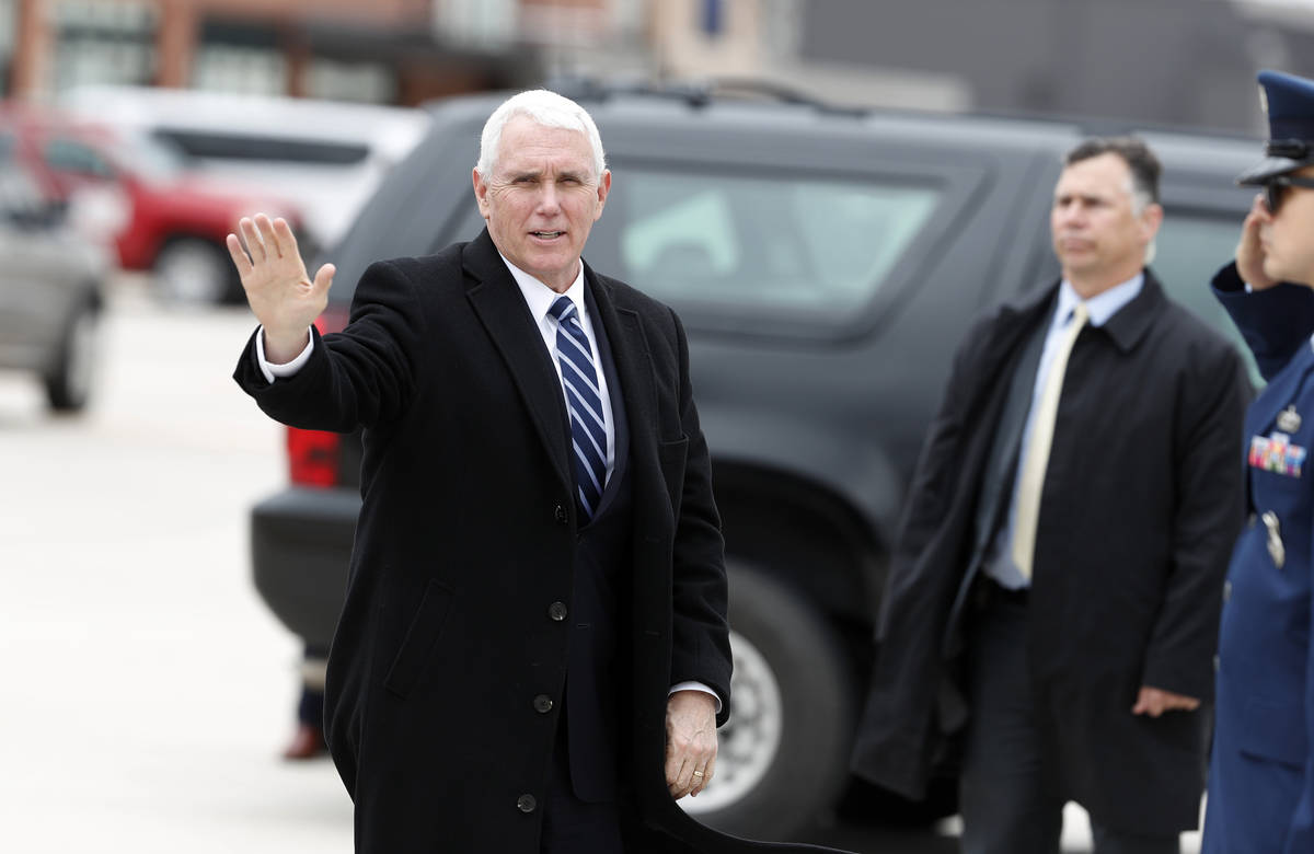 Vice President Mike Pence waves as he heads to Air Force Two to leave Peterson Air Force Base, ...