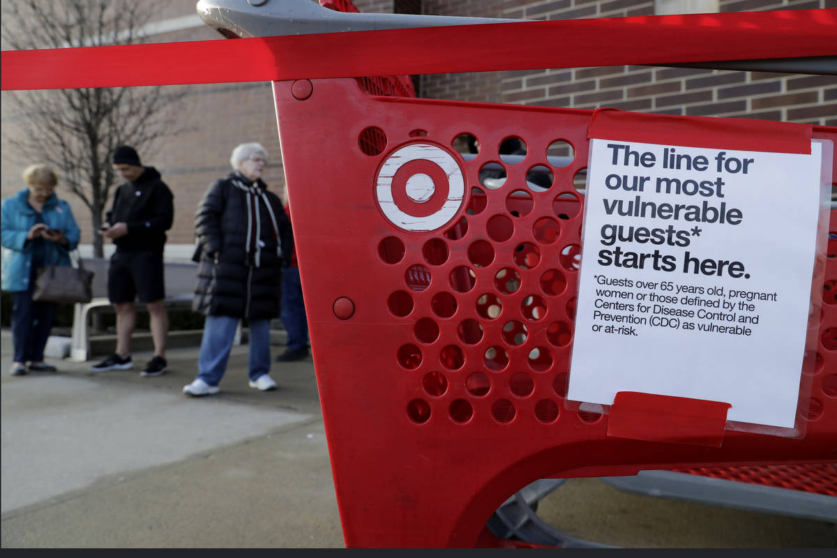Shoppers wait to enter at a Target store in Glenview, Ill., Wednesday, March 25, 2020. Grocery ...