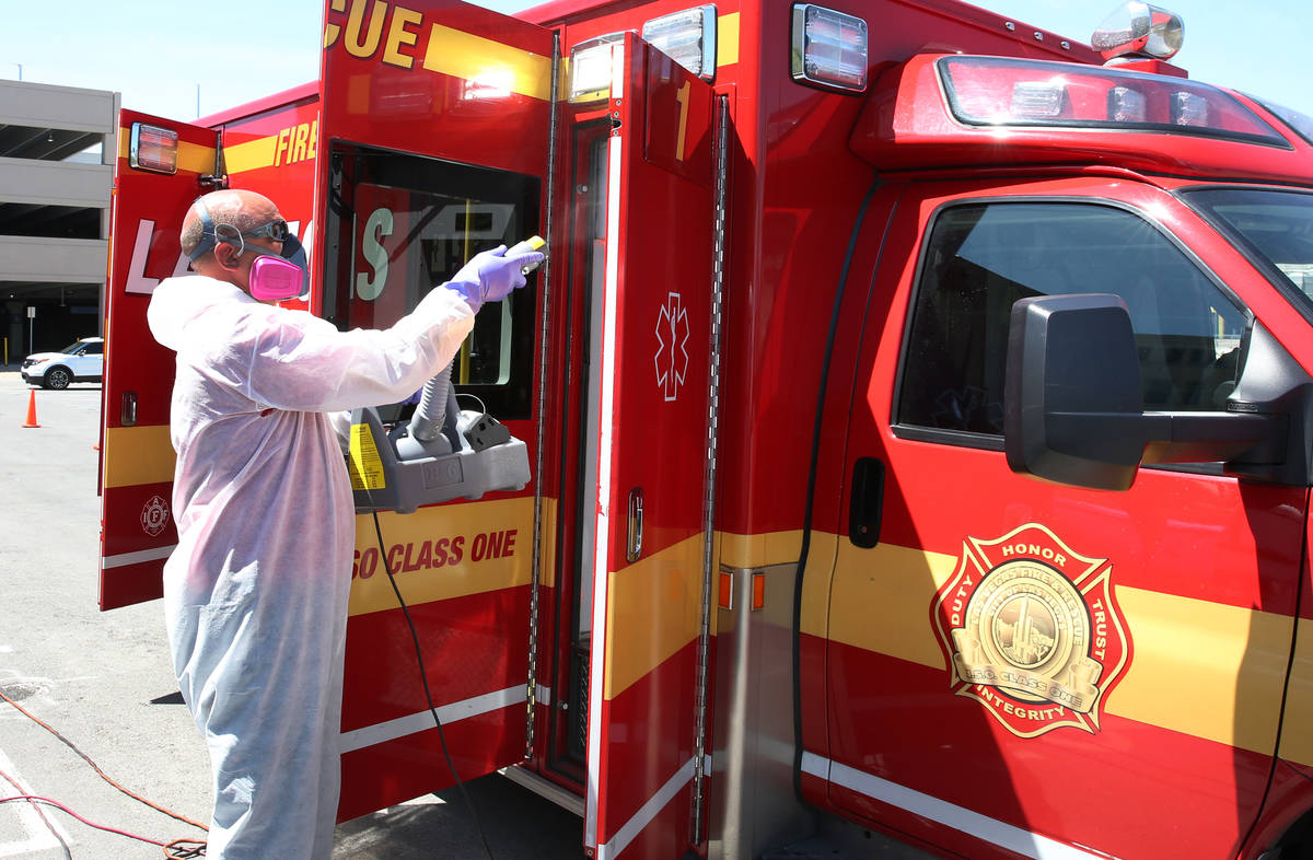 Bill Meeks, owner of Summit Restoration, disinfects a Las Vegas Fire Department Paramedic truck ...