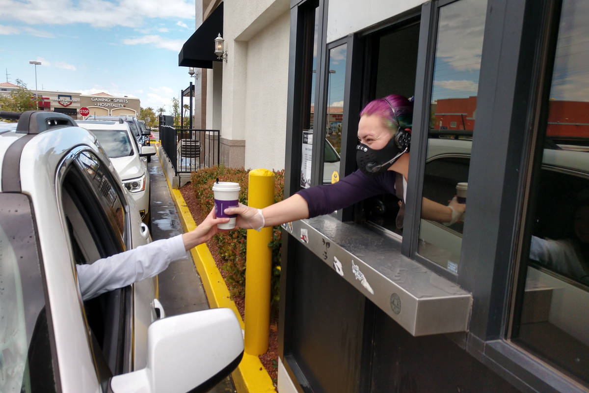 A Coffee Bean & Tea Leaf team member hands a drink to a drive-thru customer. (Coffee Bean & Tea ...