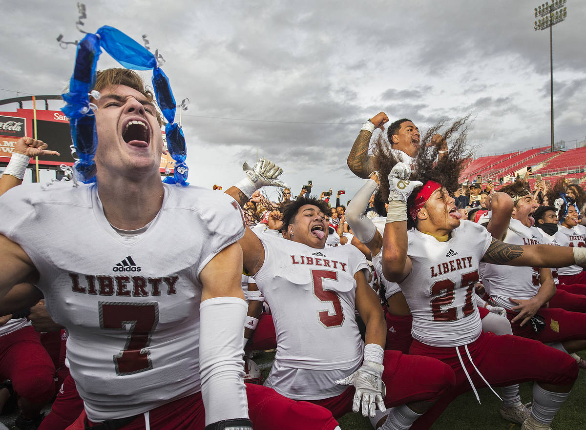 Liberty senior quarterback Kanyon Stoneking (7), celebrates with teammates Ezra Tomhoon (5) and ...