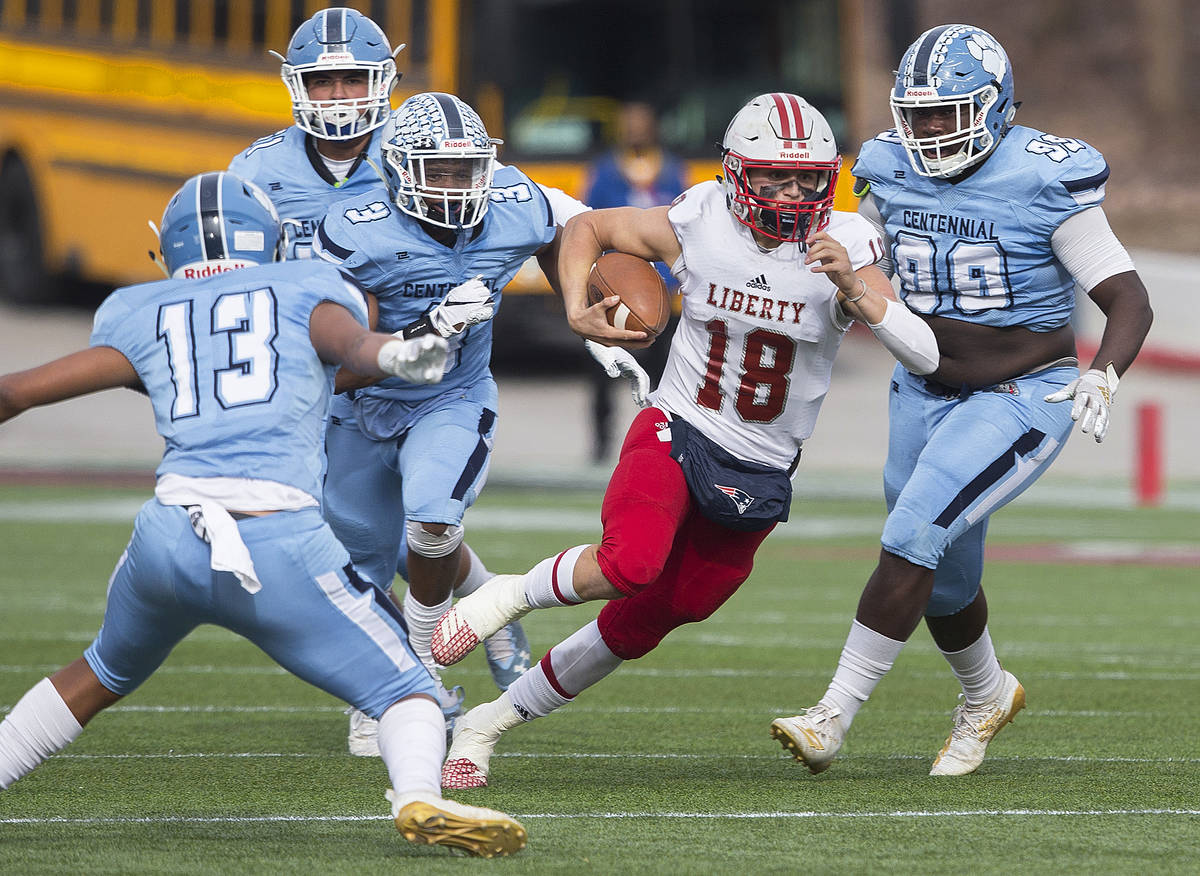 Liberty junior quarterback Daniel Britt (18) cuts up field past Centennial senior Donte Washin ...