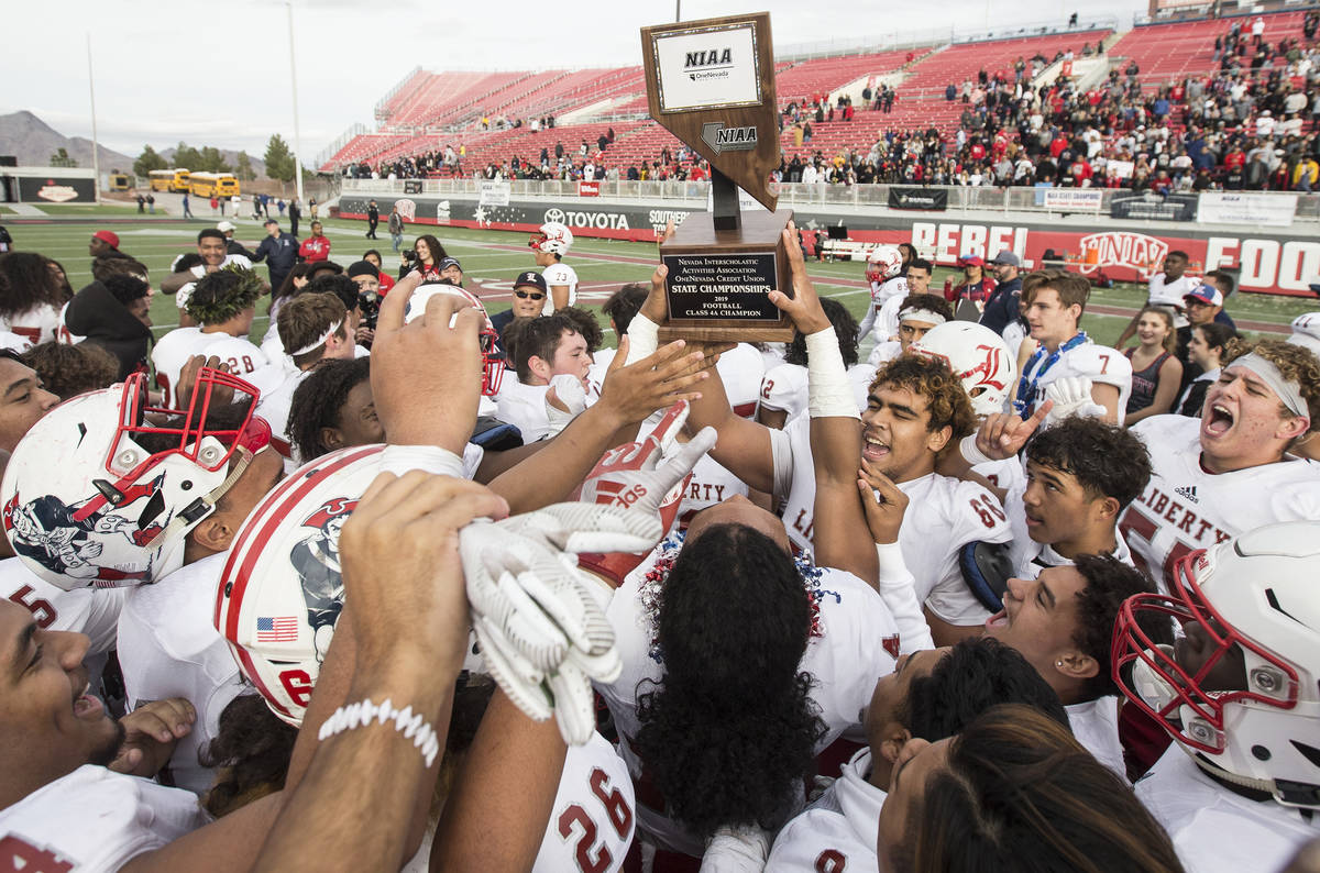 Liberty players celebrate after defeating Centennial 50-7 to win the Class 4A state football ch ...