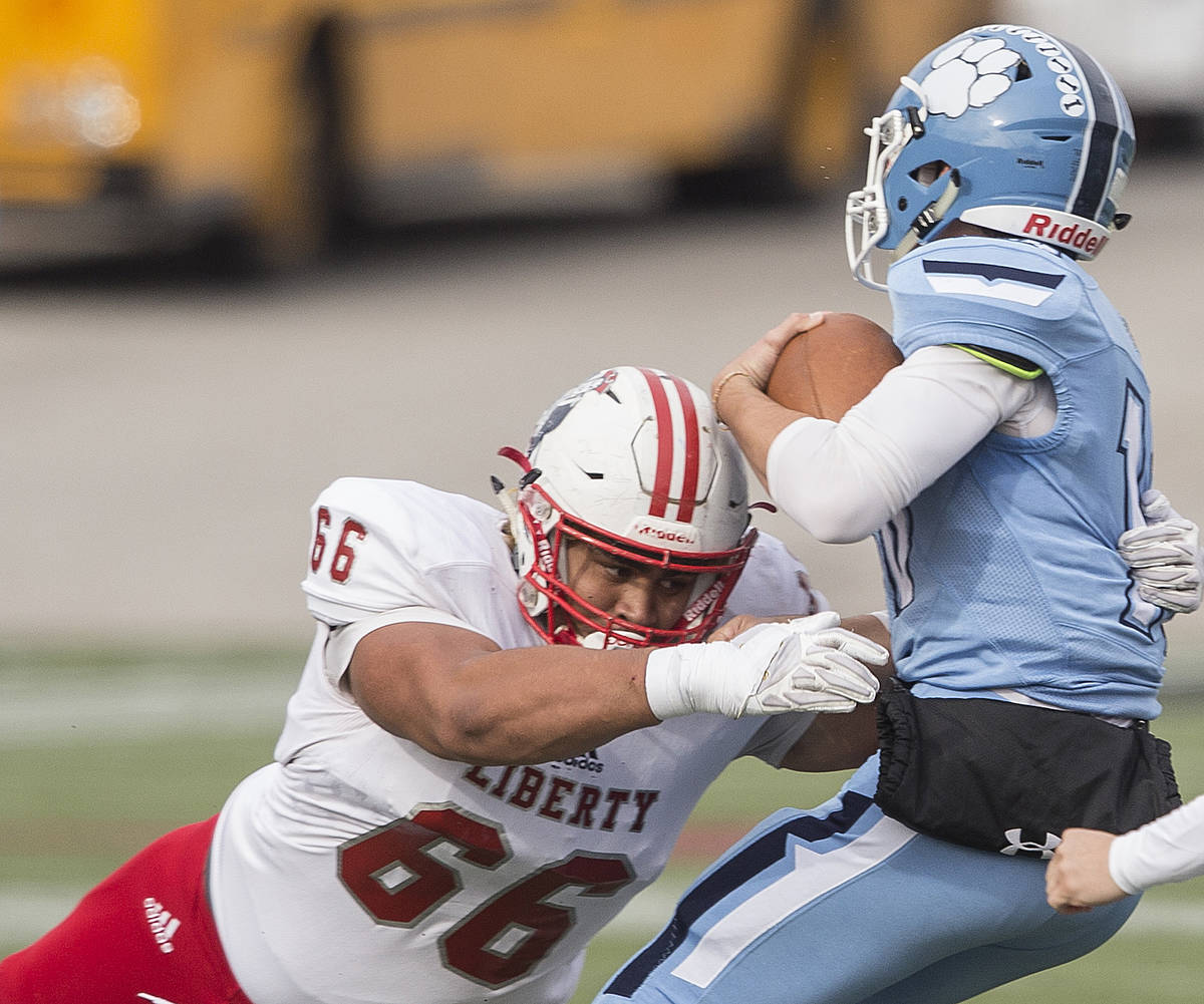 Liberty senior guard Garrett Vea (66) tackles Centennial junior Colton Tenney (10) for a loss i ...