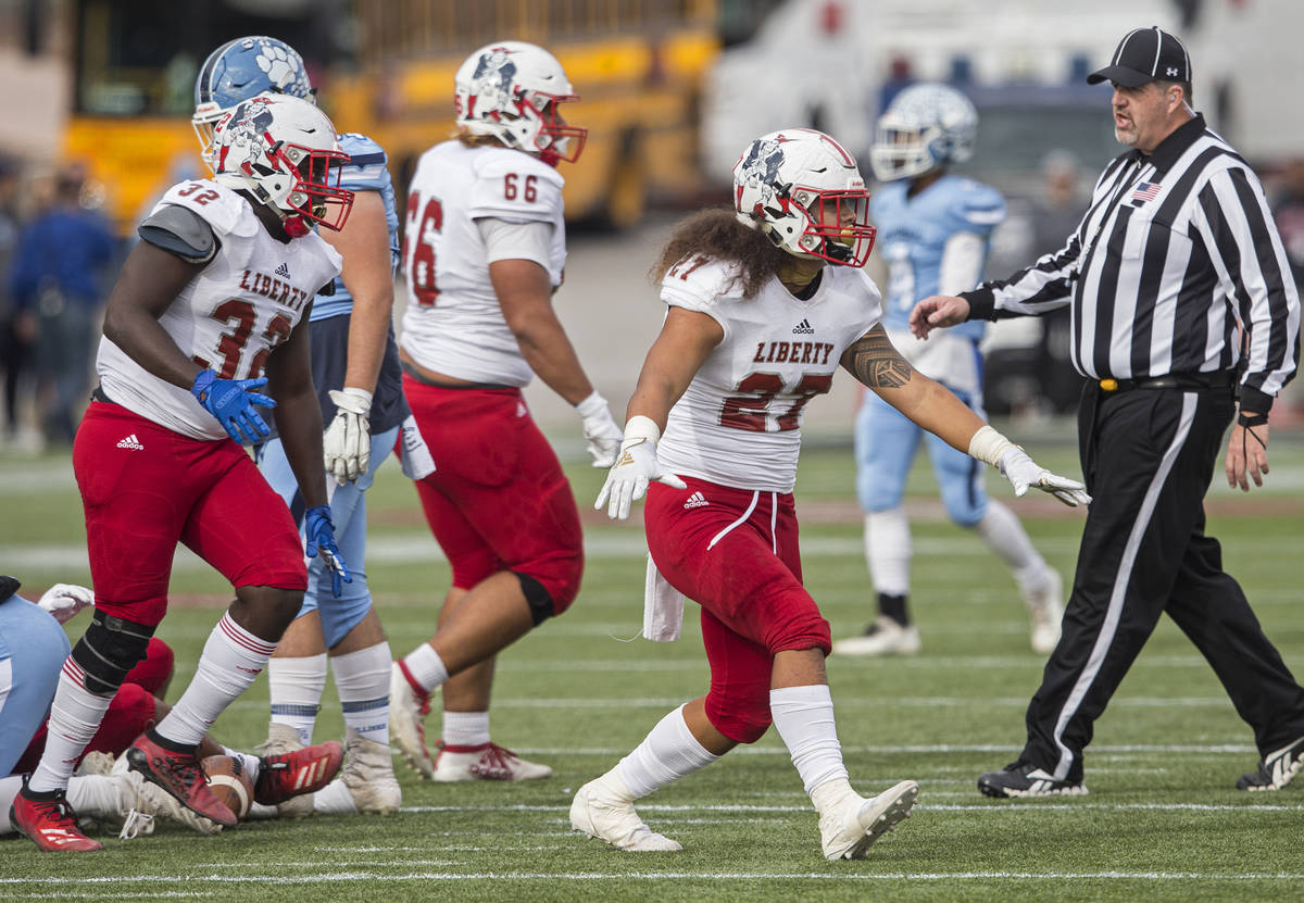 Liberty junior linebacker Jared Tufele (27), Liberty junior linebacker Zamier Marshall (32) and ...