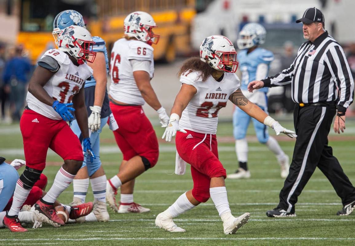 Liberty junior linebacker Jared Tufele (27), Liberty junior linebacker Zamier Marshall (32) and ...