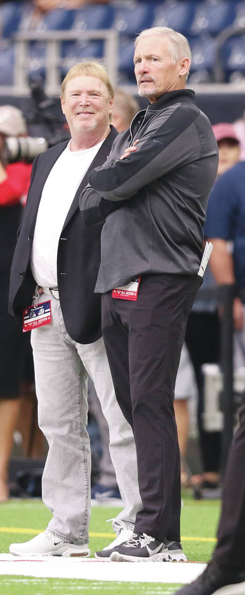Oakland Raiders owner Mark Davis, left, and general manager Mike Mayock meet on the field prior ...