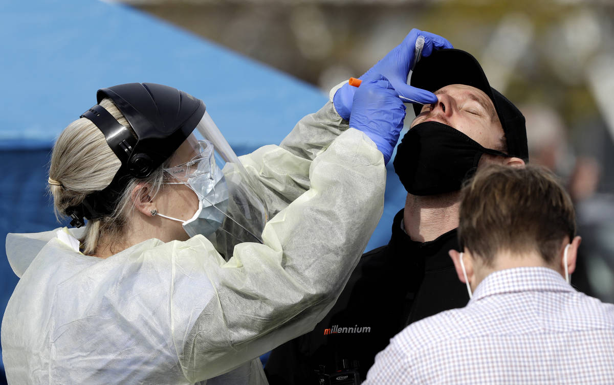 In this Friday, April 17, 2020, photo, medical staff test a supermarket employee who volunteere ...