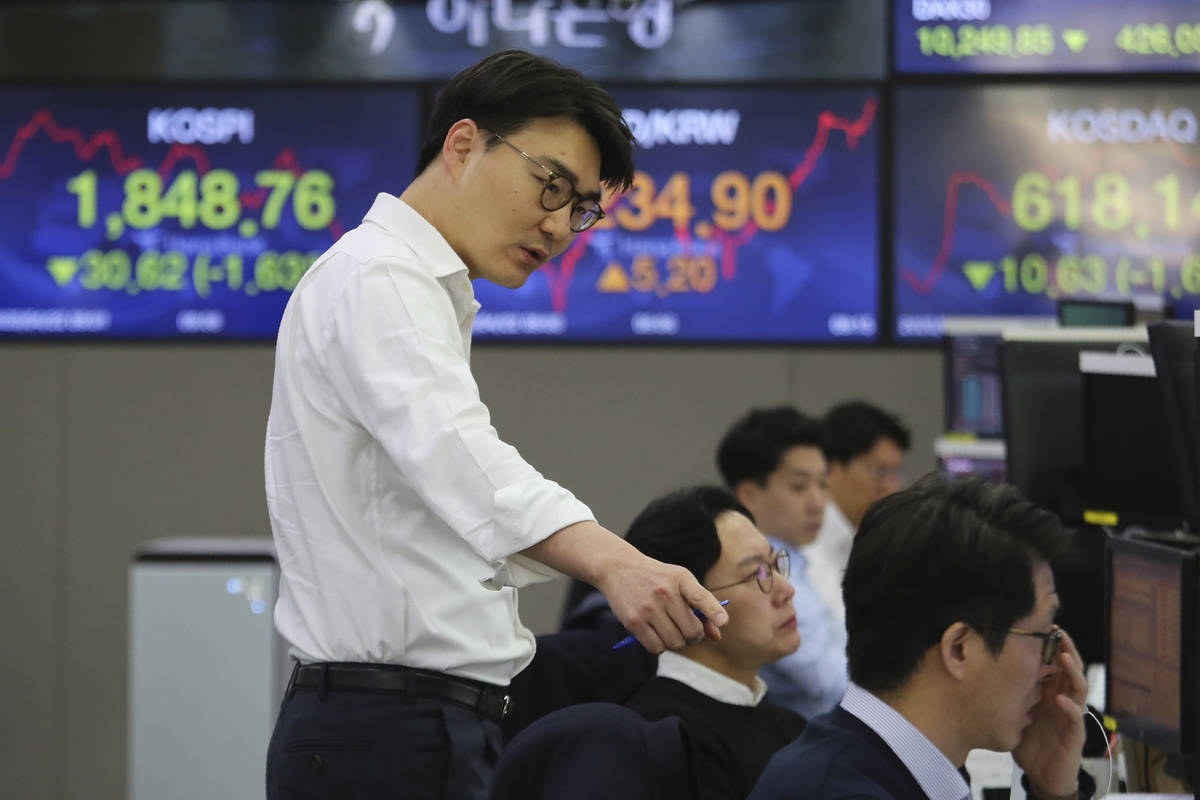 A currency trader gestures at the foreign exchange dealing room of the KEB Hana Bank headquarte ...