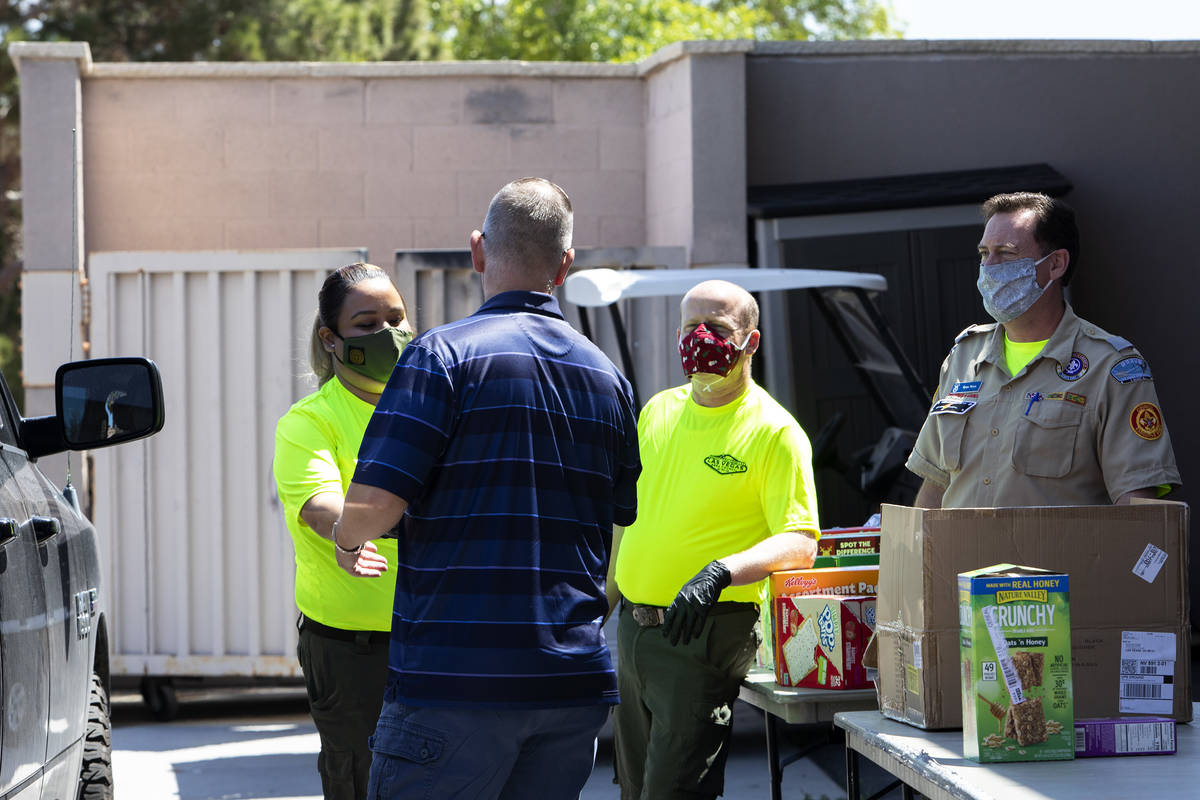 Las Vegas Council of the Boy Scouts employees receive a donation during their "no touch" drive ...