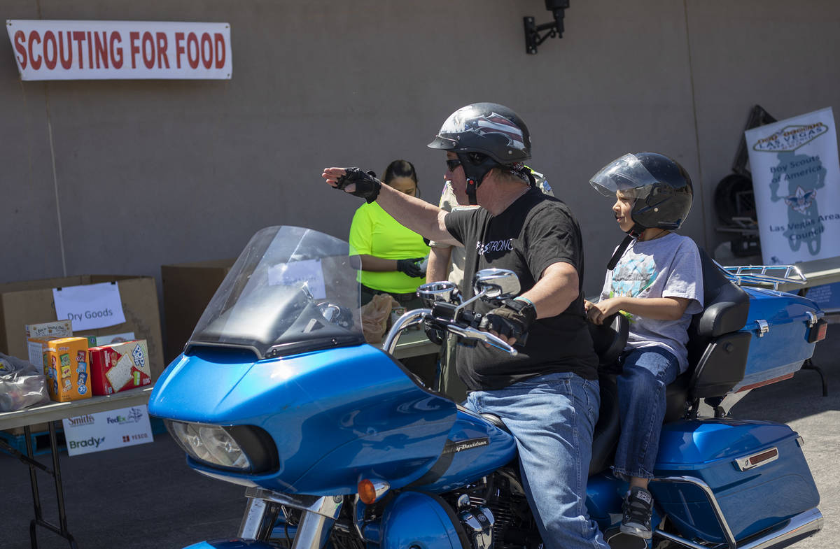 A donator and his son salute the Las Vegas Council of the Boy Scouts as the organization hosts ...