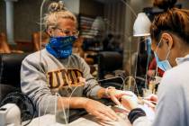 Logan Nash, left, gets a manicure, with all the proper social distancing requirements, includin ...