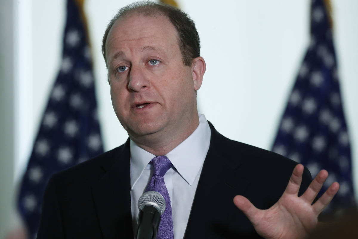 Colorado Governor Jared Polis makes a point during a news conference to update the state's effo ...