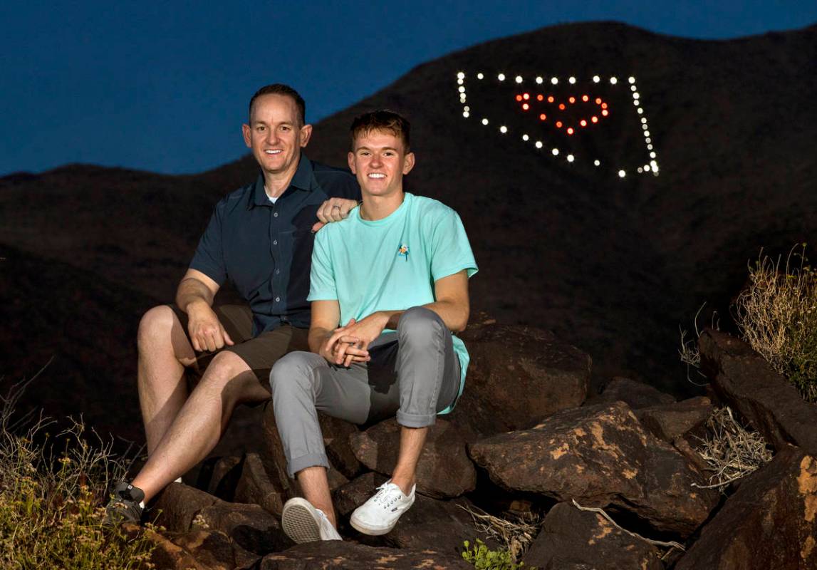 David Koch, left, and son Mason sit on rocks at the trail head below their Nevada light display ...