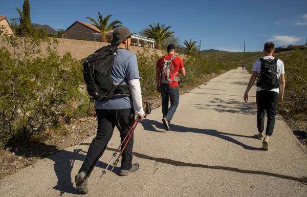David Koch, left, with brother Michael and son Mason begin a trek back up to their Nevada light ...