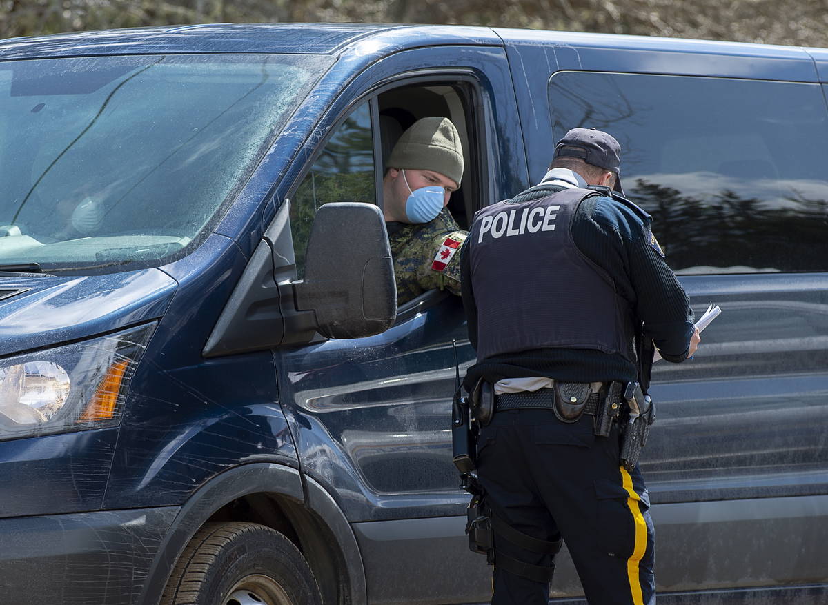 A soldier talks with an RCMP officer at a checkpoint in Portapique, N.S. on Thursday, April 23, ...
