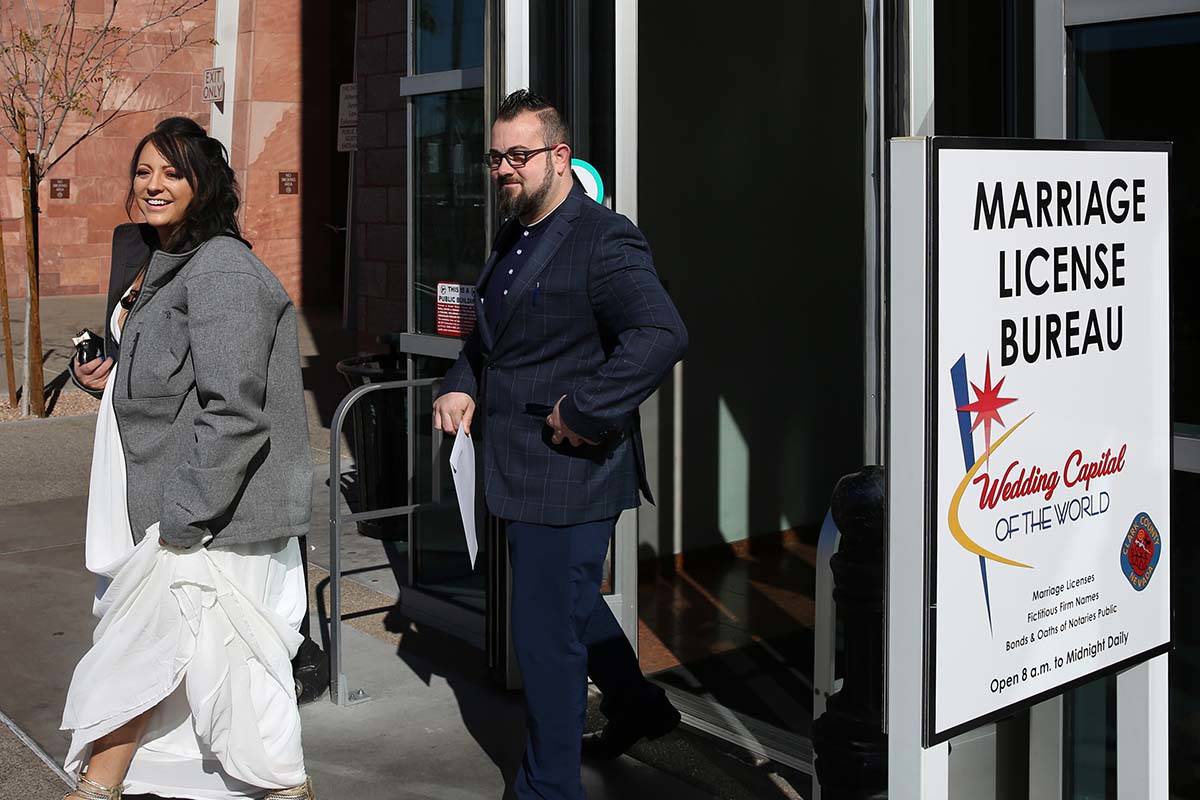 Marylyn Barnett and Trevor Pennock, both of Nebraska, leave the Marriage License Bureau after g ...