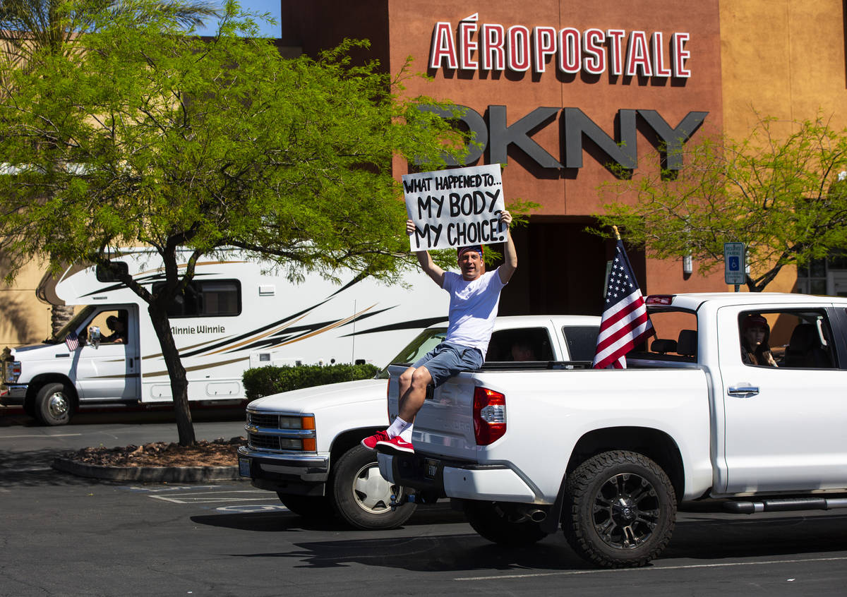 A man holds up a sign at the Las Vegas South Premium Outlets before participating in a "ca ...